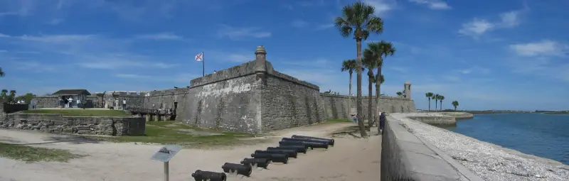 Coquina walls of the Castillo de San Marcos with cannons on the lawn
